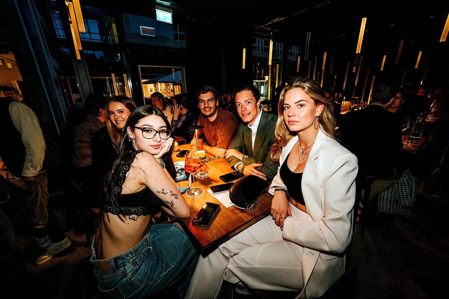 Gruppe am Tisch in einer dunklen Bar