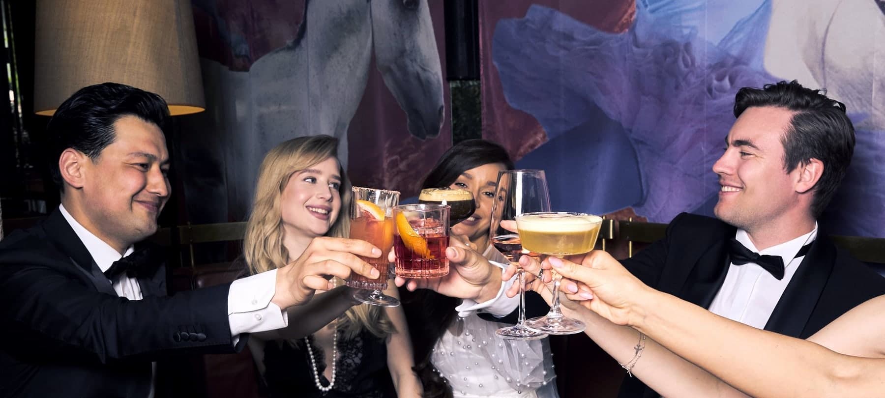 Fünf Gäste stoßen mit ihren Cocktails an